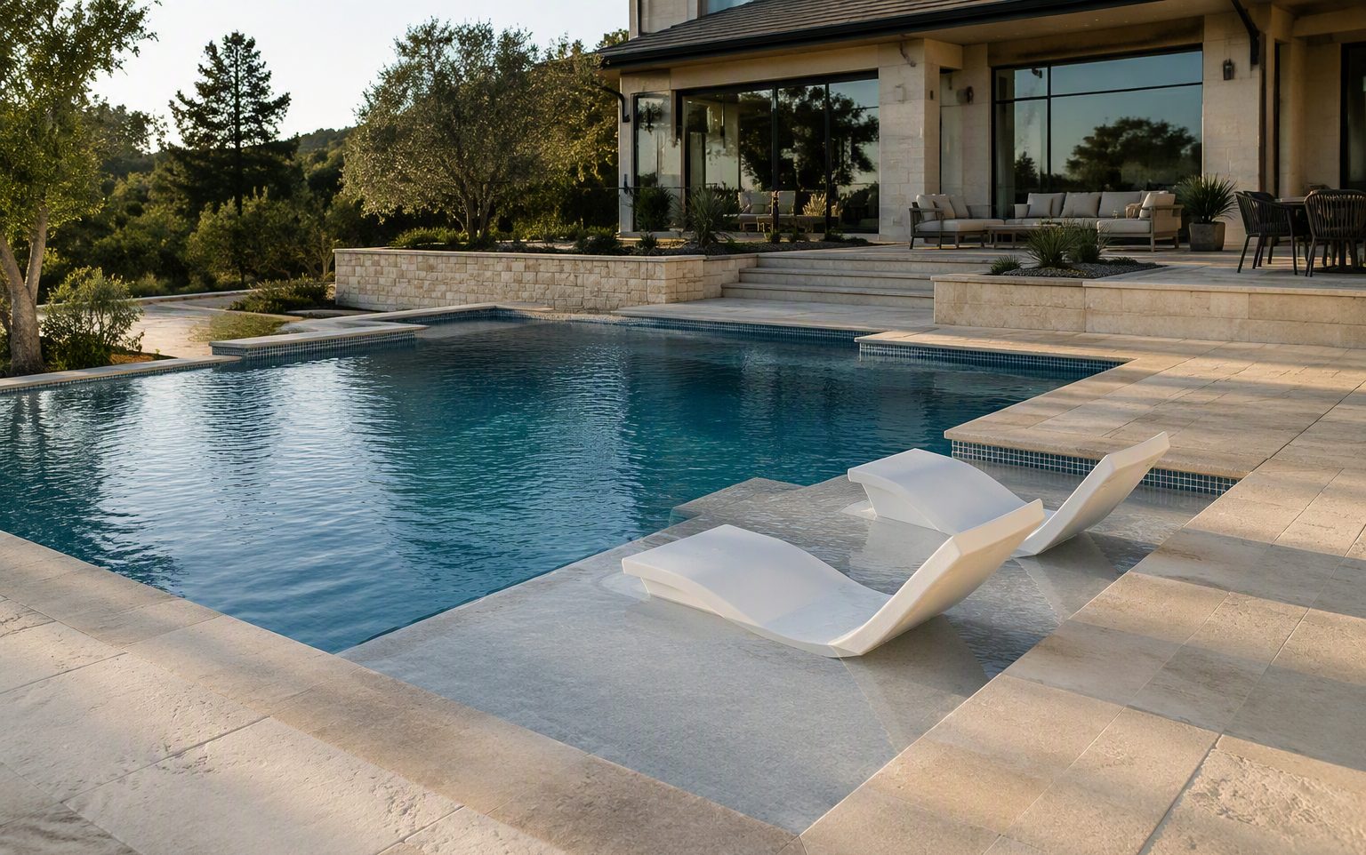 Newly completed geometric in-ground pool with a submerged tanning ledge and white in-water loungers